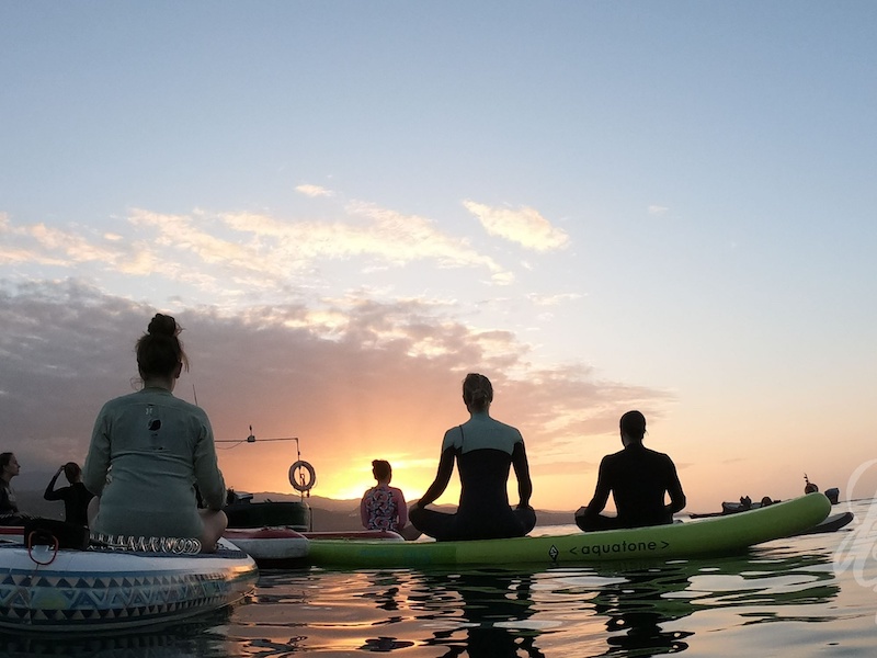 digital nomads doing yoga on the water