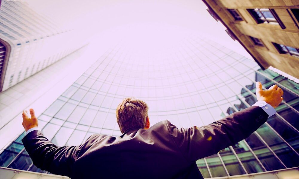 Business person looking up at a skyscraper