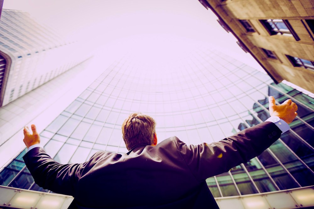 Business person looking up at a skyscraper